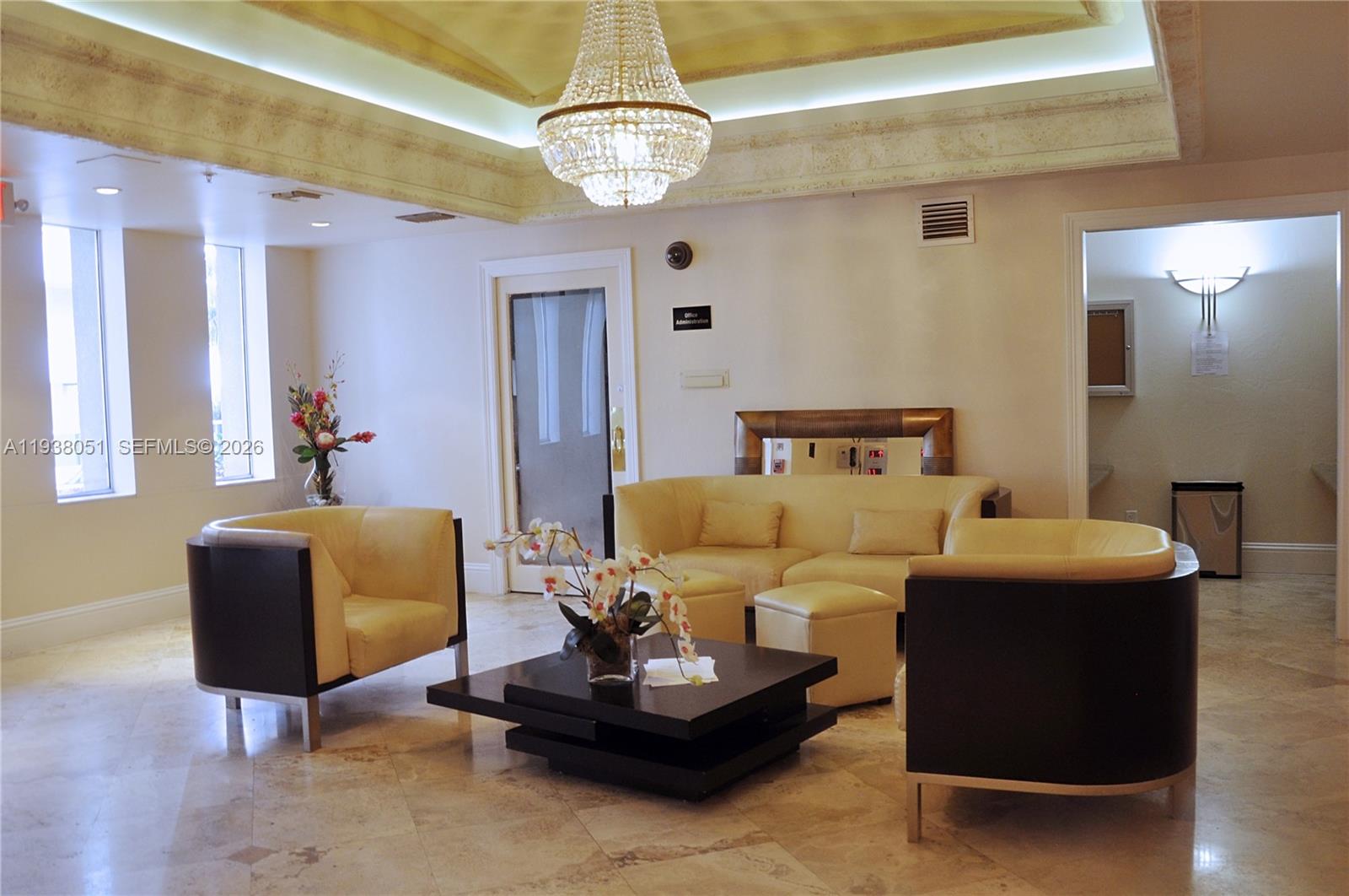 9195 Collins Avenue, Unit 611 Surfside, FL 33154 - Photo 27 of 33 a living room with furniture and a chandelier