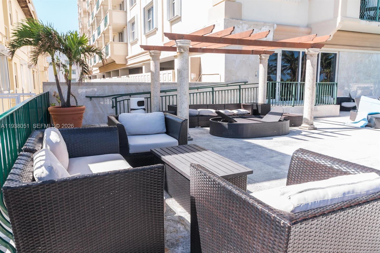 9195 Collins Avenue, Unit 611 Surfside, FL 33154 - Photo 33 of 33 a view of a patio with couches and a table and chairs with wooden floor