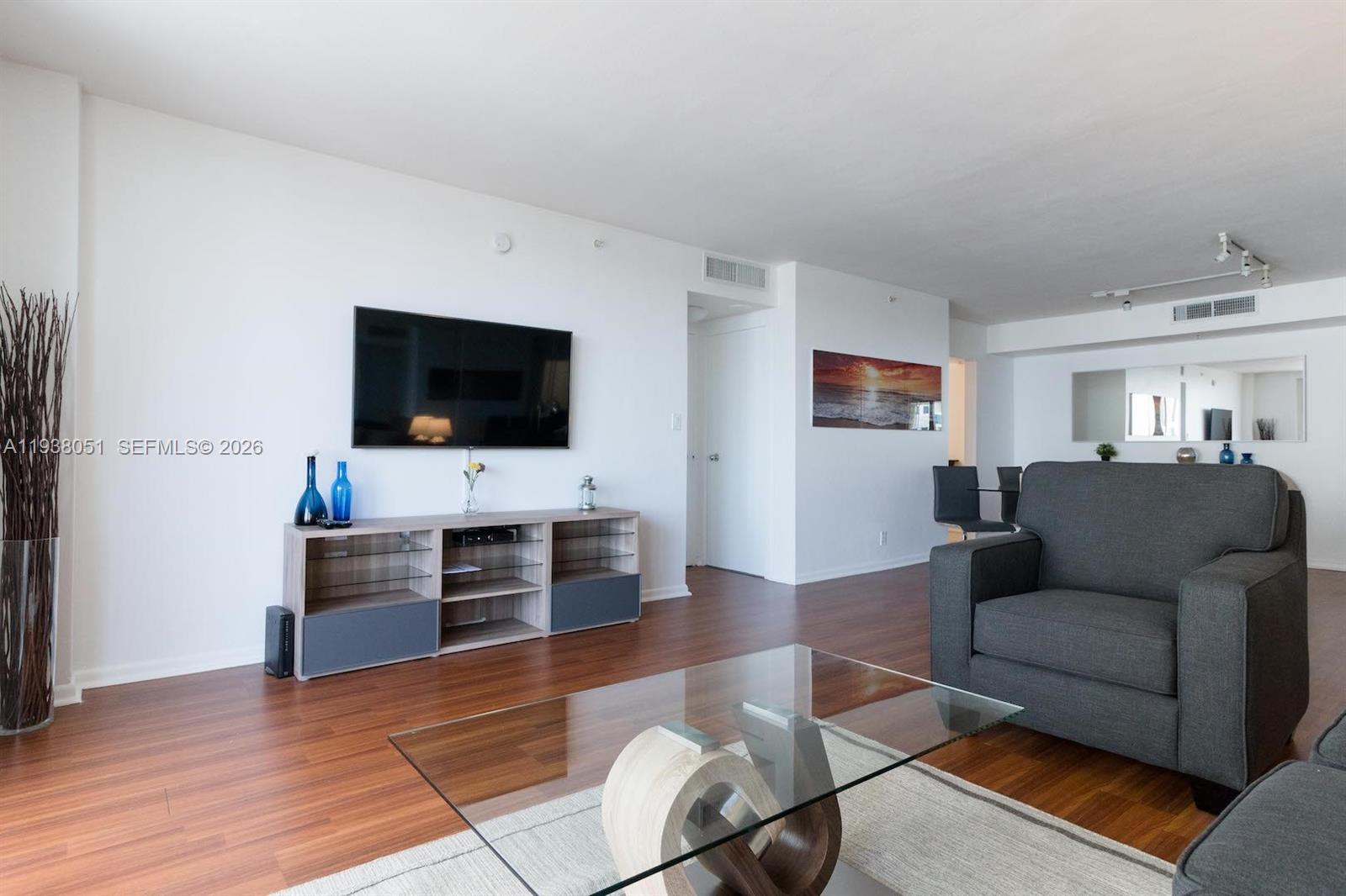 9195 Collins Avenue, Unit 611 Surfside, FL 33154 - Photo 4 of 33 a living room with furniture and a flat screen tv