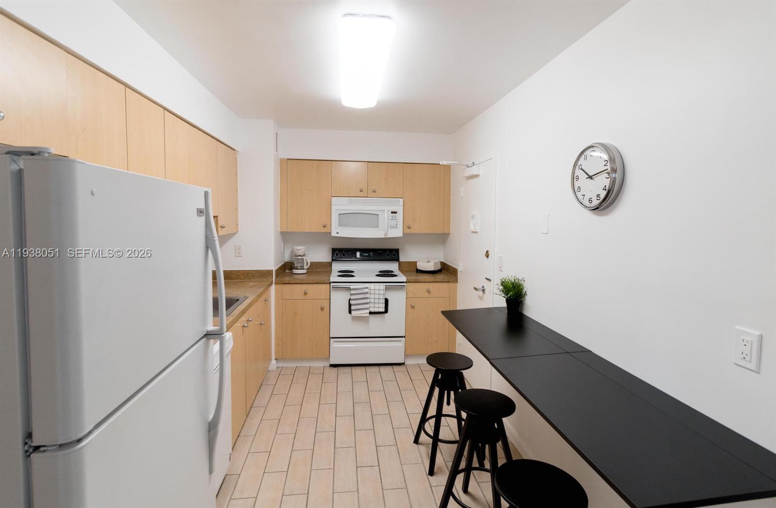 9195 Collins Avenue, Unit 611 Surfside, FL 33154 - Photo 9 of 33 a kitchen with a refrigerator and a stove top oven