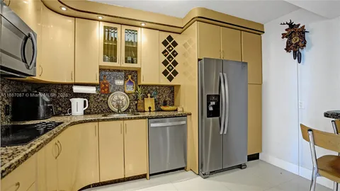 a kitchen with stainless steel appliances granite countertop a refrigerator and a sink