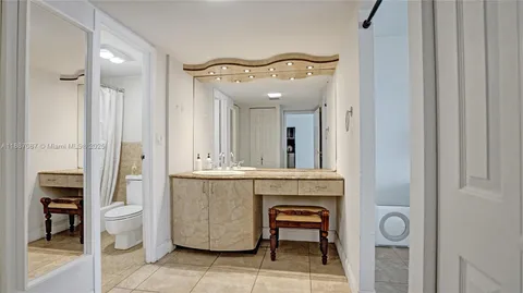 a spacious bathroom with a toilet a sink and mirror