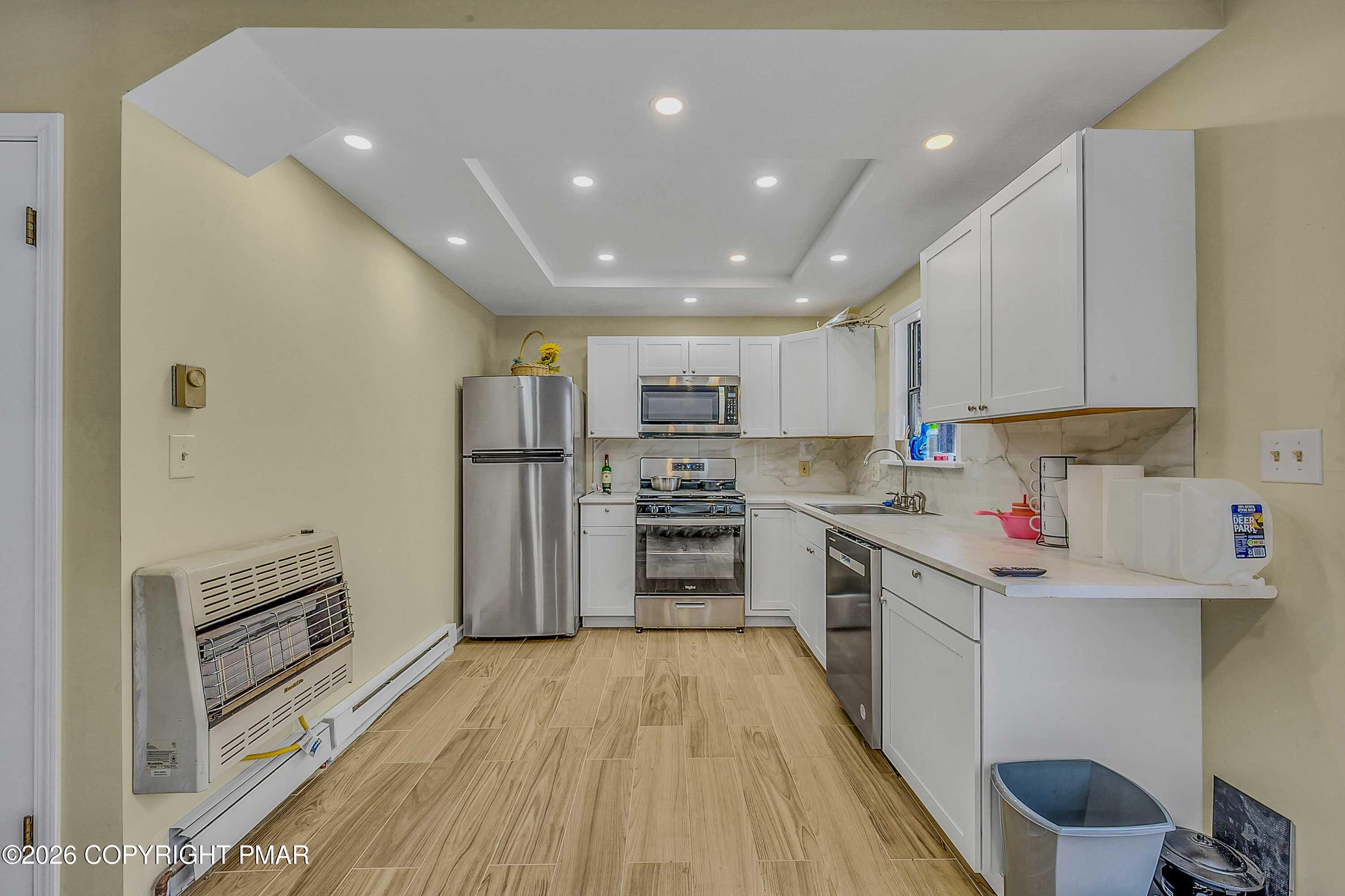 1027 Valley Road Newfoundland, PA 18445 - Photo 10 of 31 a kitchen with stainless steel appliances granite countertop a refrigerator oven a sink dishwasher and white cabinets with wooden floor