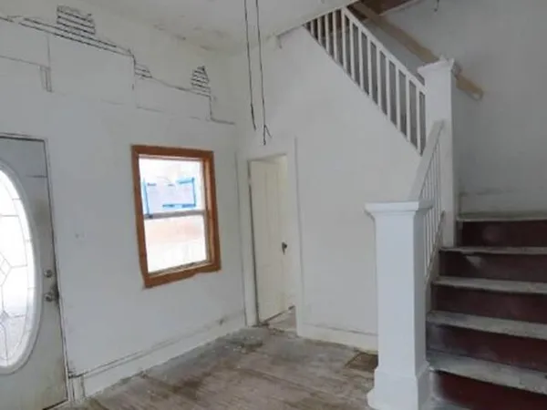 a view of hallway with stairs and wooden floor