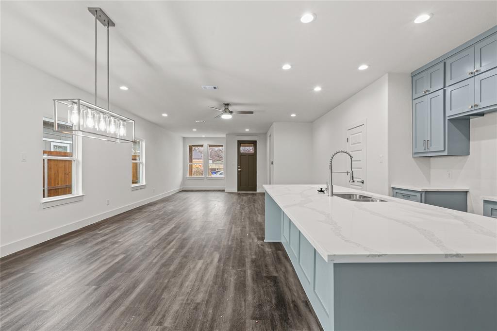 3335 Spring Avenue Dallas, TX 75215 - Photo 11 of 22 a large kitchen with kitchen island a stove a sink a refrigerator and chandelier