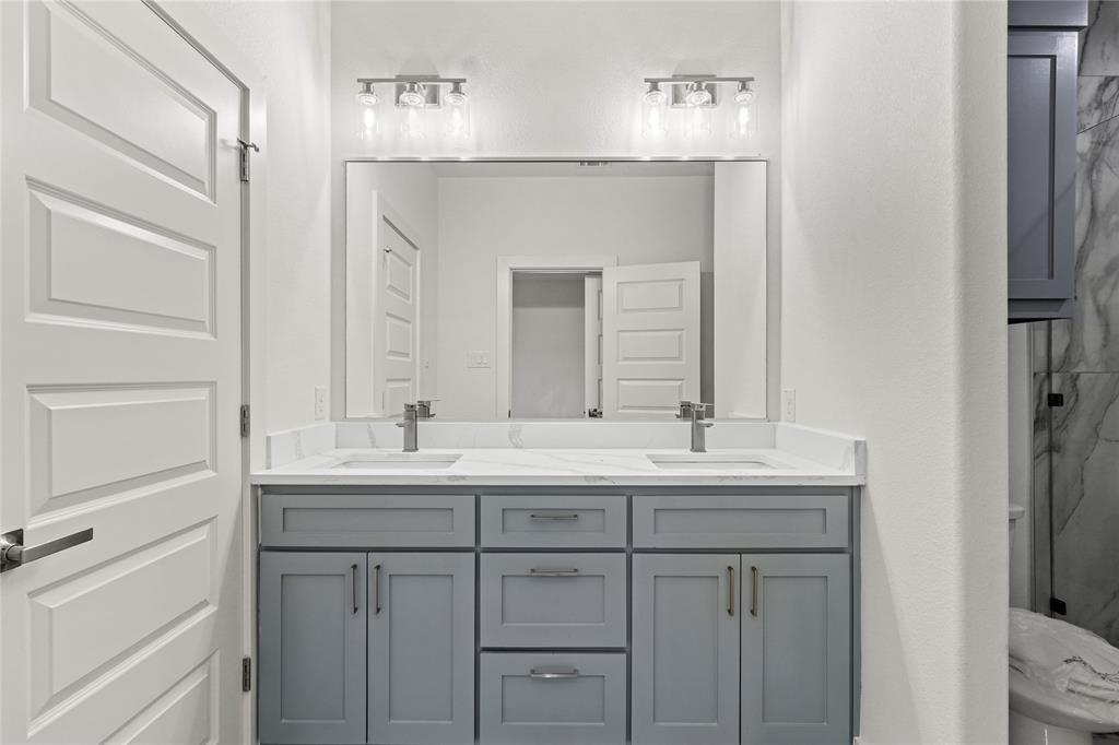 3335 Spring Avenue Dallas, TX 75215 - Photo 14 of 22 a bathroom with a double vanity sink and a mirror