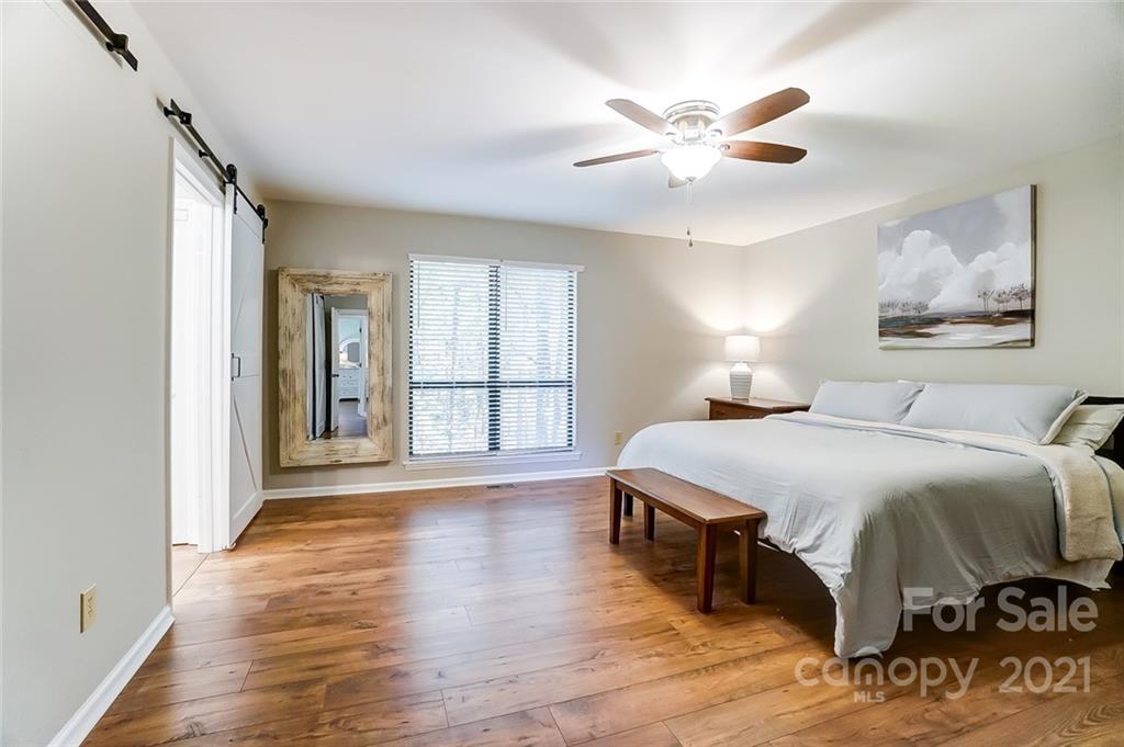 31016 Executive Point, Unit 15 Tega Cay, SC 29708 - Photo 12 of 35 a spacious bedroom with a bed and a large window