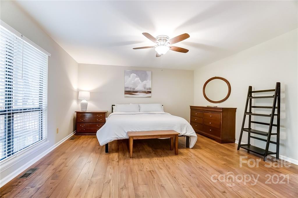 31016 Executive Point, Unit 15 Tega Cay, SC 29708 - Photo 13 of 35 a bedroom with a bed and a chandelier