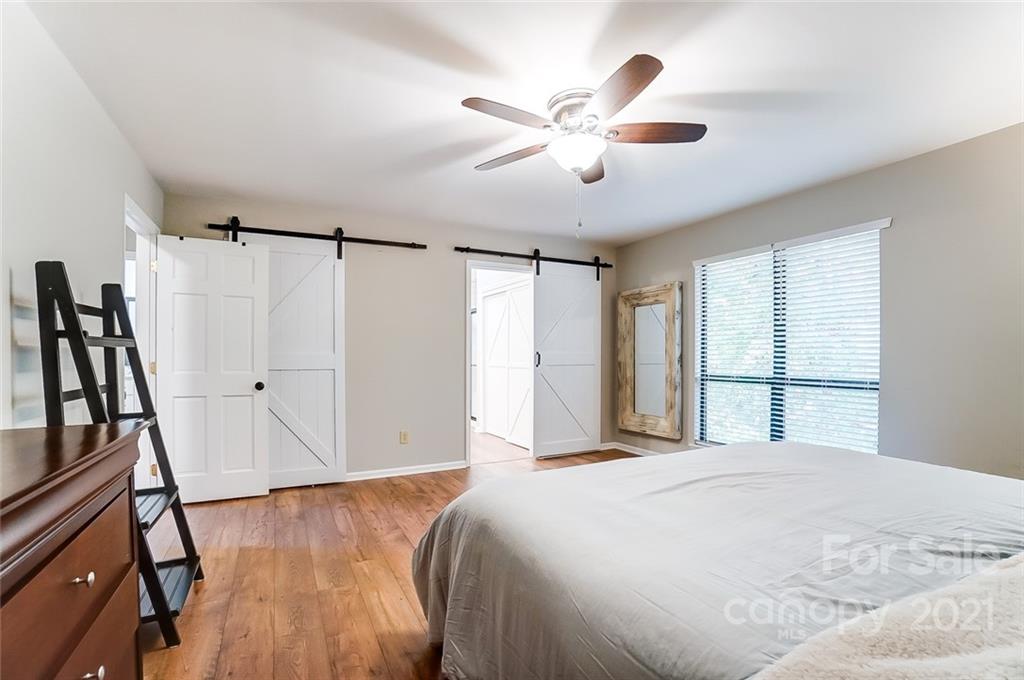 31016 Executive Point, Unit 15 Tega Cay, SC 29708 - Photo 14 of 35 a bedroom with a large bed and a chandelier