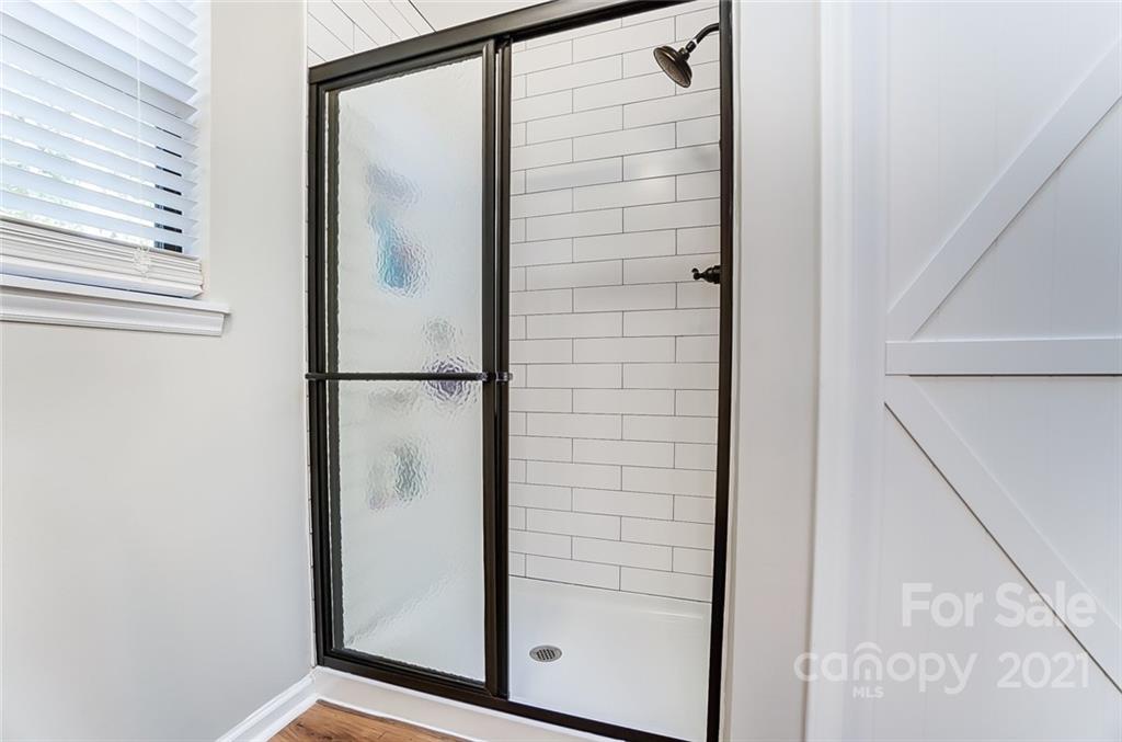 31016 Executive Point, Unit 15 Tega Cay, SC 29708 - Photo 16 of 35 a bathroom with a glass shower door and mirror