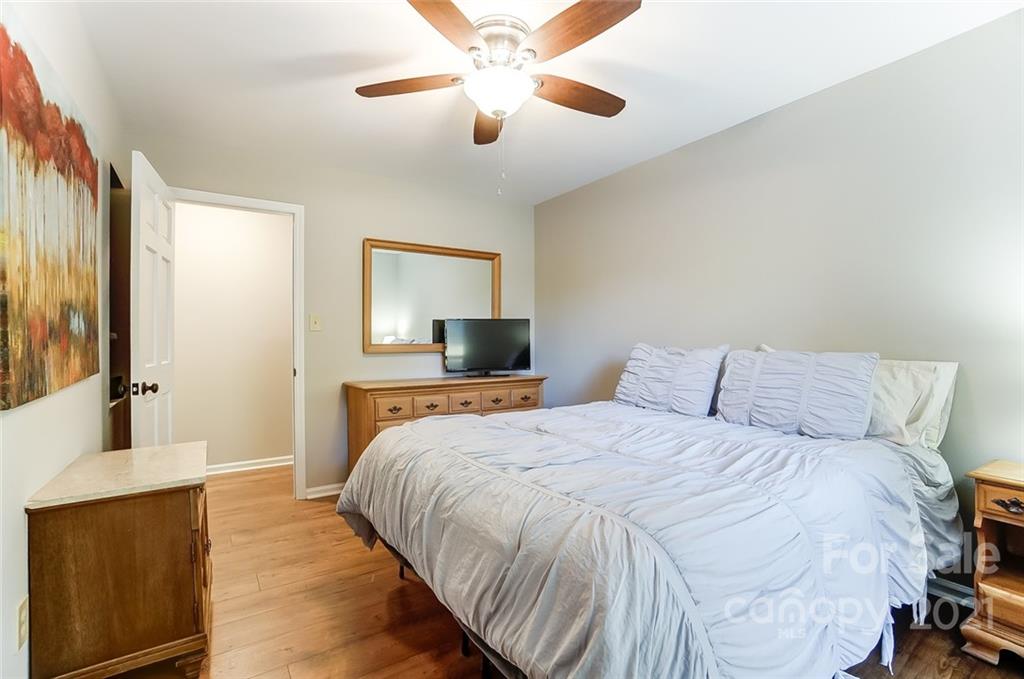 31016 Executive Point, Unit 15 Tega Cay, SC 29708 - Photo 17 of 35 a bedroom with a large bed and a chandelier