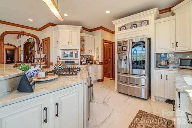 a kitchen with stainless steel appliances granite countertop a refrigerator and a sink