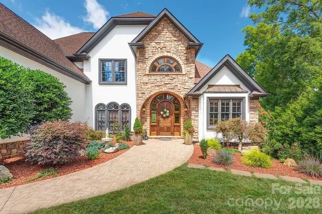 a front view of a house with a garden and plants