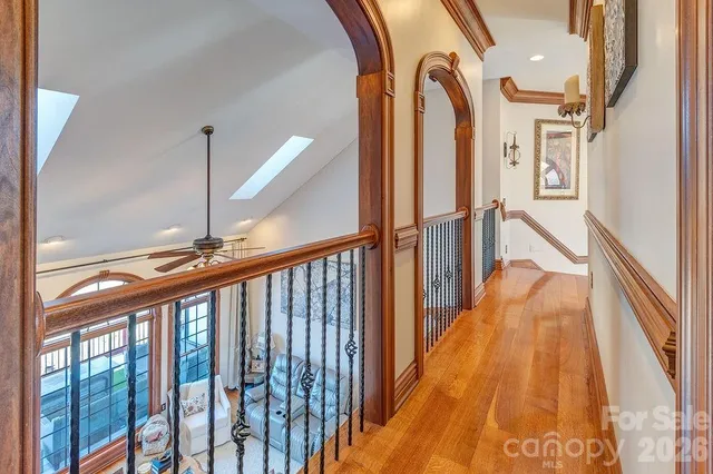 a view of staircase with lots of frames on wall and a large window