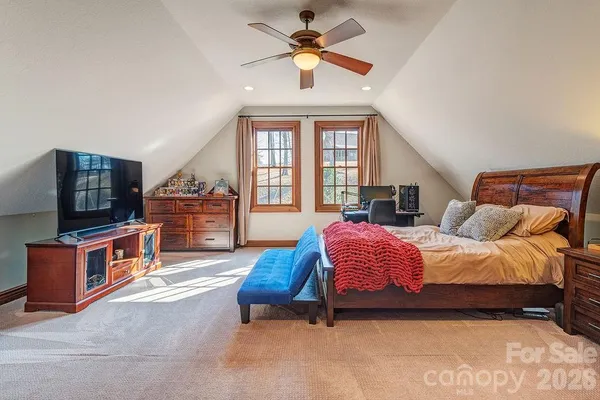 a spacious bedroom with a bed and a chandelier