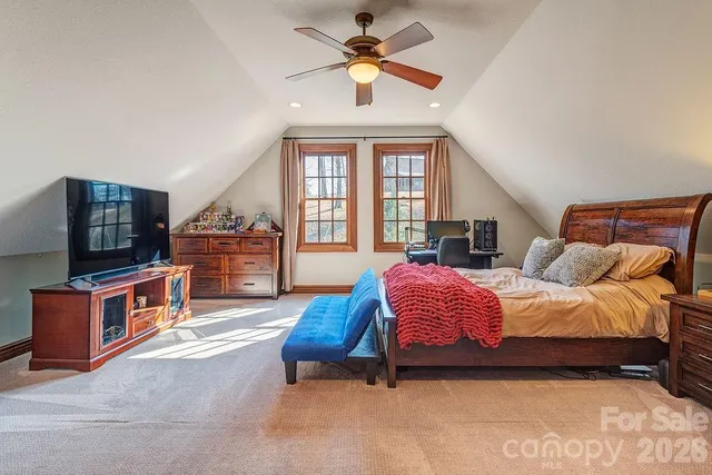 a spacious bedroom with a bed and a chandelier