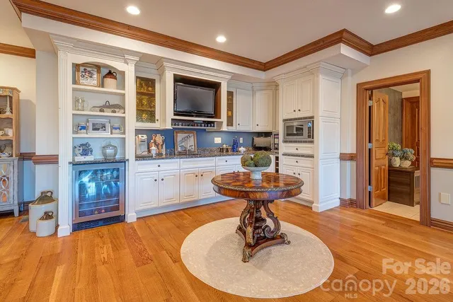a living room with stainless steel appliances furniture a fireplace and a flat screen tv