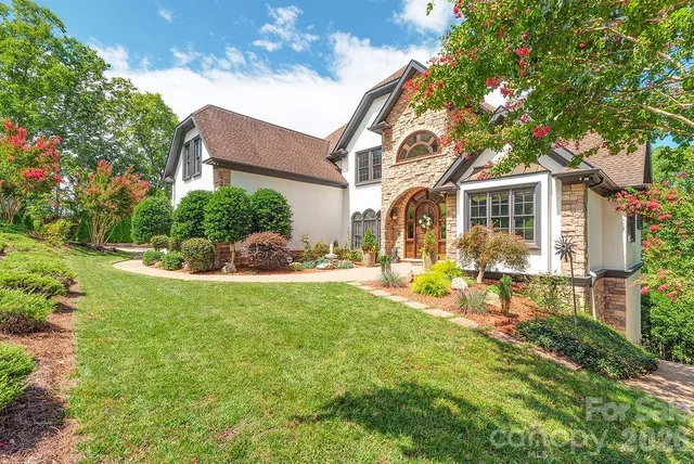 a front view of a house with garden and sitting area