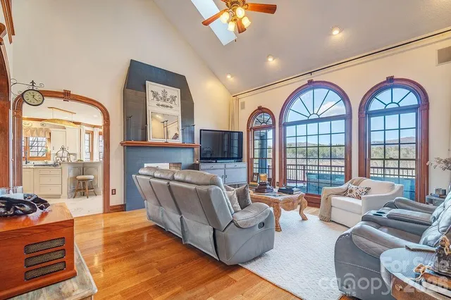 a living room with furniture a chandelier and a flat screen tv