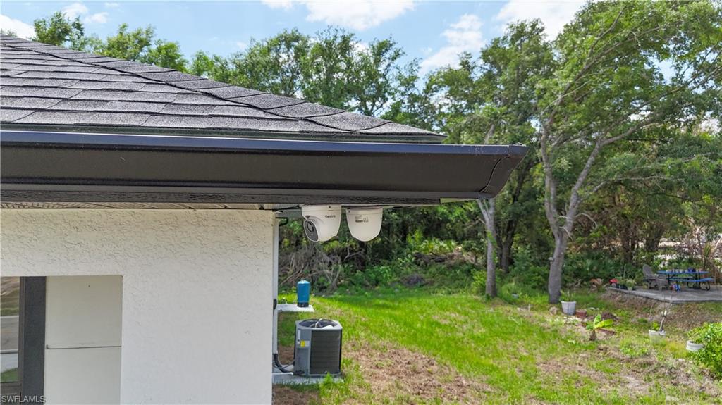613-615 West 12th Street Lehigh Acres, FL 33972 - Photo 2 of 32 a small yard with a table and chairs under an umbrella