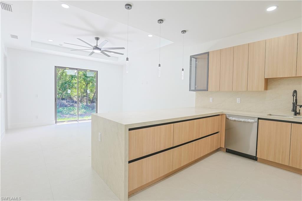 613-615 West 12th Street Lehigh Acres, FL 33972 - Photo 3 of 32 a kitchen with granite countertop white cabinets and white appliances