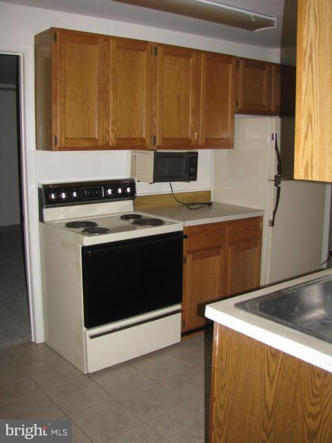 17981 Possum Point Road Dumfries, VA 22026 - Photo 23 of 27 a kitchen with a stove top oven sink and cabinets