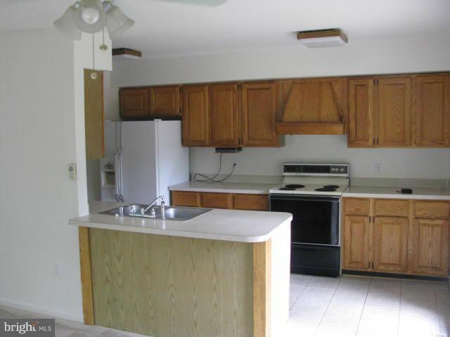 17981 Possum Point Road Dumfries, VA 22026 - Photo 8 of 27 a kitchen with granite countertop a sink a stove and cabinets