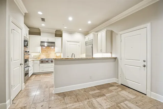 a kitchen with kitchen island white cabinets and refrigerator