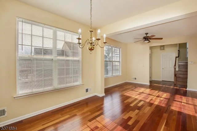 a view of a room with wooden floor and windows
