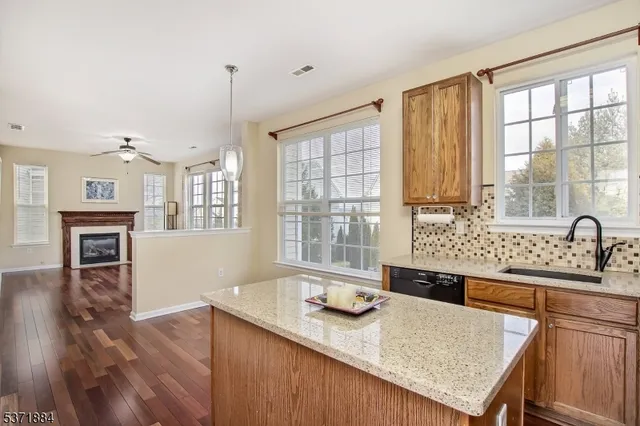 a kitchen with granite countertop a stove a sink a refrigerator and wooden floor