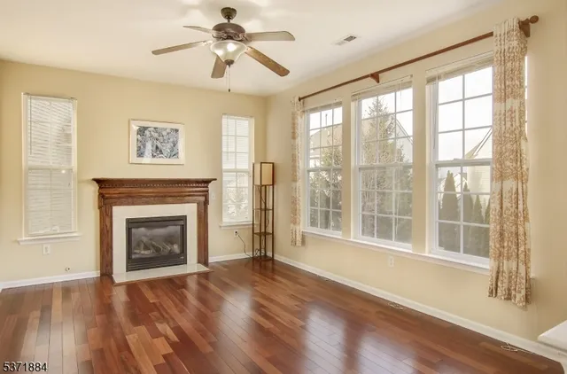 a view of empty room with wooden floor and fireplace