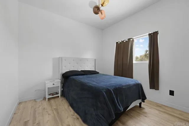 a bedroom with a bed and a chandelier