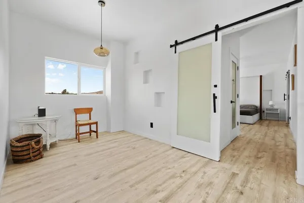 a view of a room with wooden floor and a window