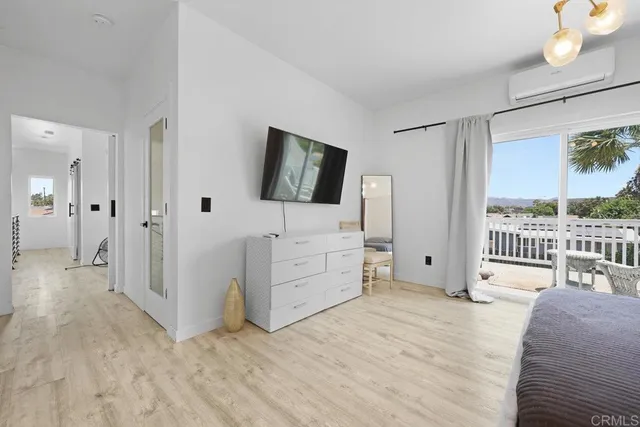 a view of a bedroom with wooden floor and windows