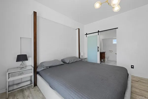 a bedroom with a bed and a flat tv screen on the dresser