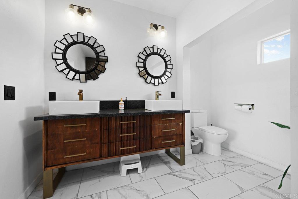 12953 Carriage Road Poway, CA 92064 - Photo 26 of 42 a bathroom with a toilet sink and mirror