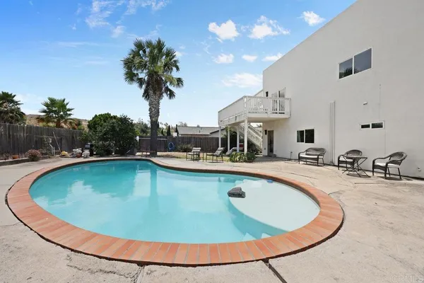 a view of a swimming pool with a yard and plants