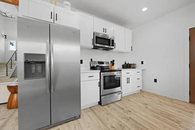 a kitchen with stainless steel appliances a refrigerator stove and microwave