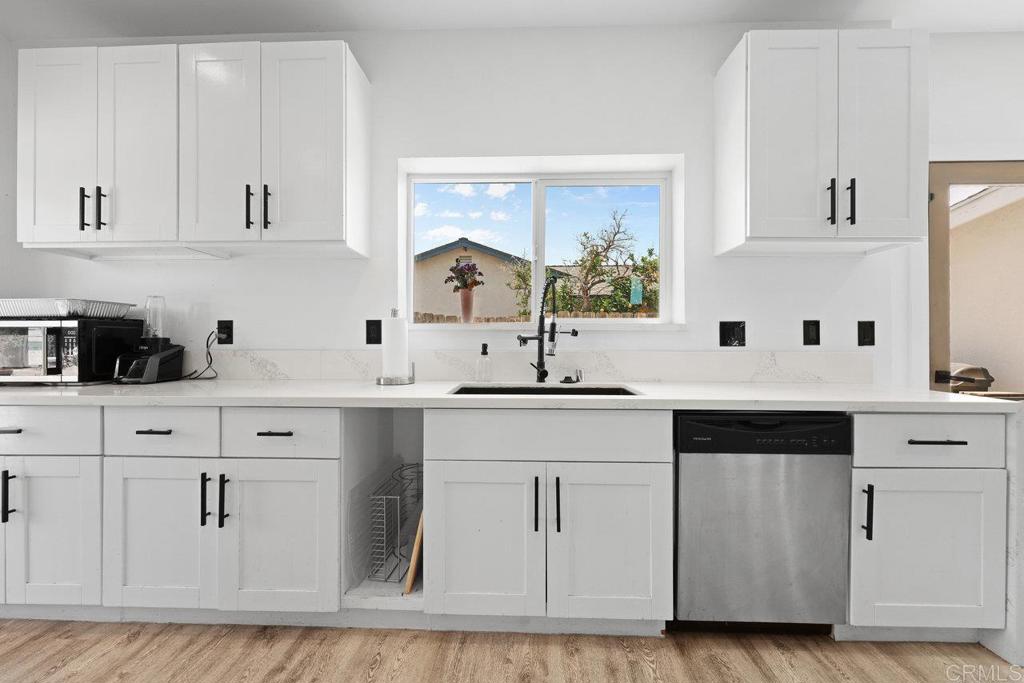 12953 Carriage Road Poway, CA 92064 - Photo 10 of 42 a kitchen with white cabinets and sink