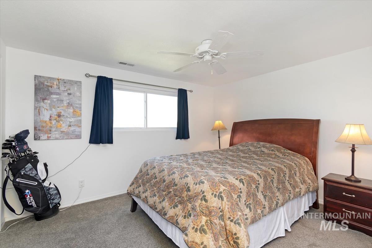 10178 West Fox Ridge Drive Boise, ID 83709 - Photo 22 of 36 Bedroom featuring carpet flooring, a window with curtains, and a ceiling fan
