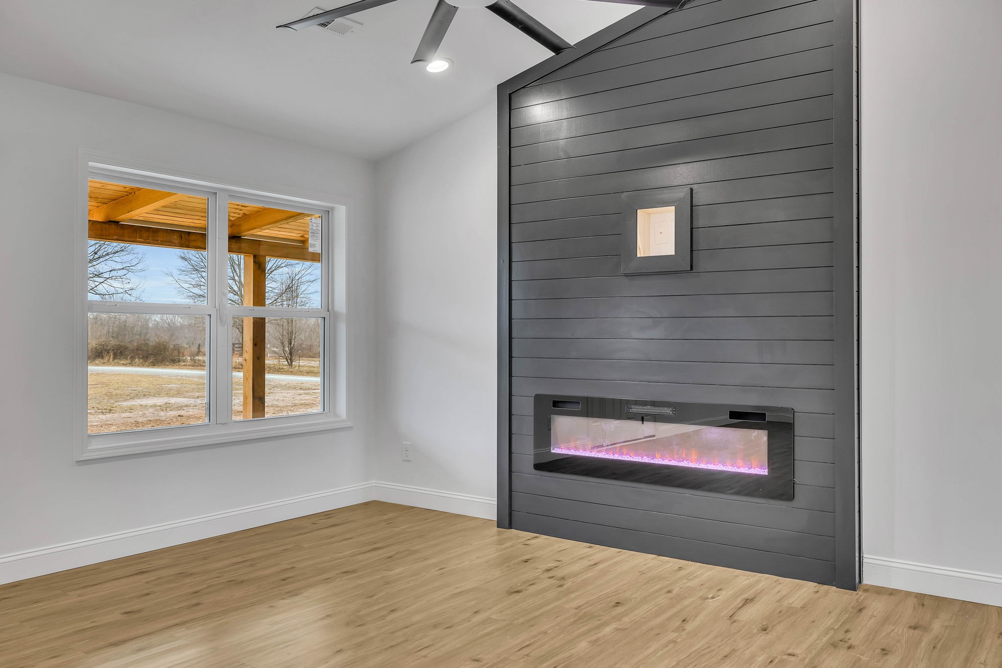 129 Colonial Road Hohenwald, TN 38462 - Photo 11 of 33 a view of an empty room with wooden floor and a window