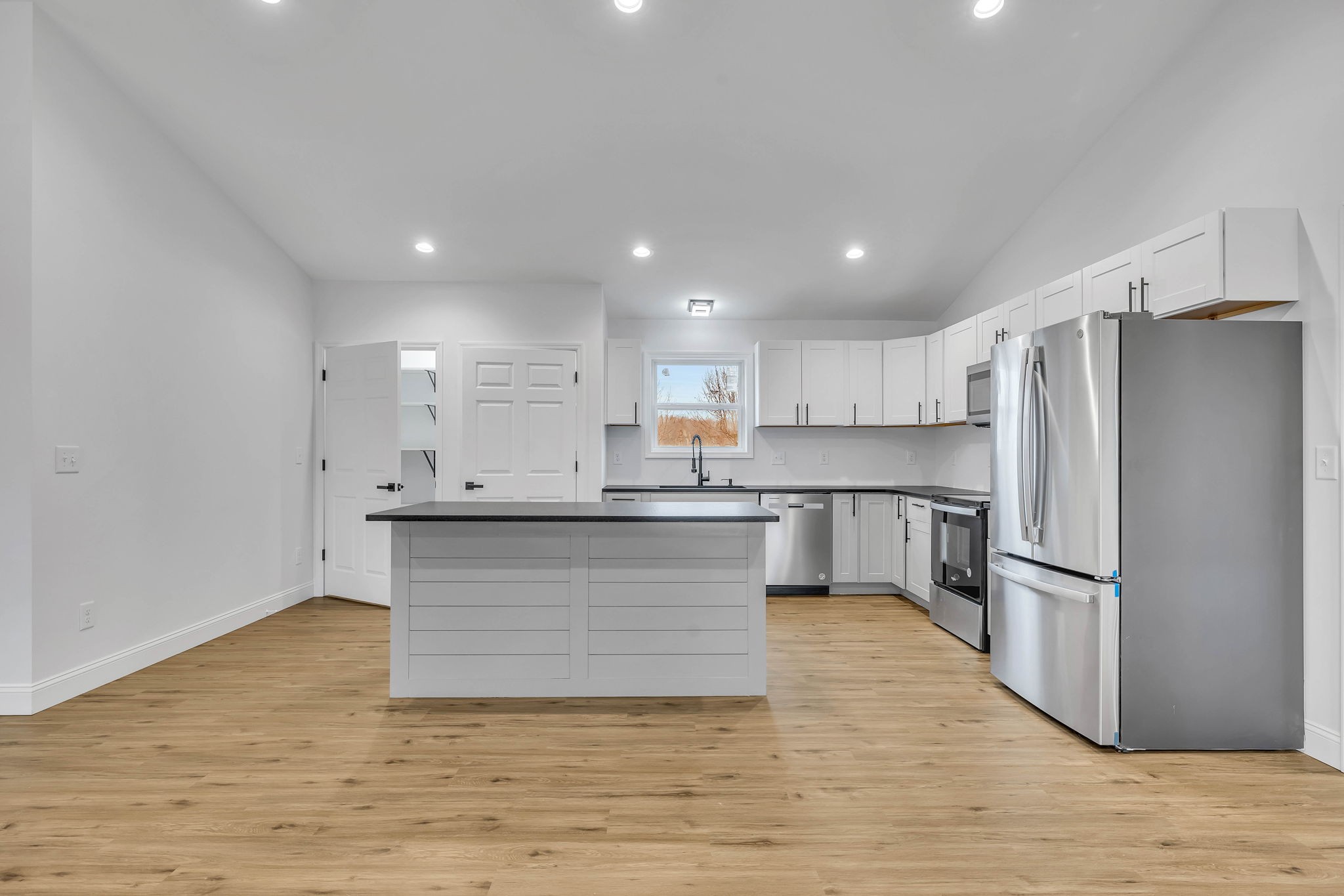 129 Colonial Road Hohenwald, TN 38462 - Photo 16 of 33 a kitchen with a refrigerator and white cabinets