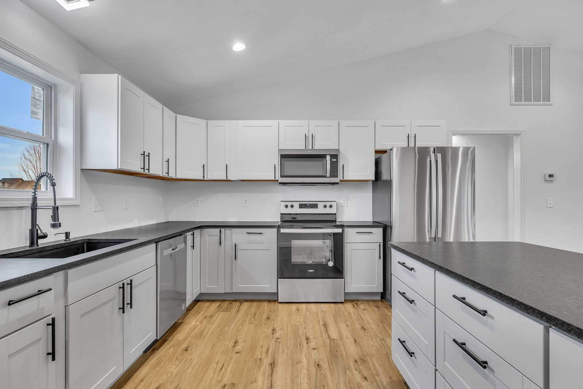 129 Colonial Road Hohenwald, TN 38462 - Photo 19 of 33 a kitchen with granite countertop a refrigerator sink and white cabinets