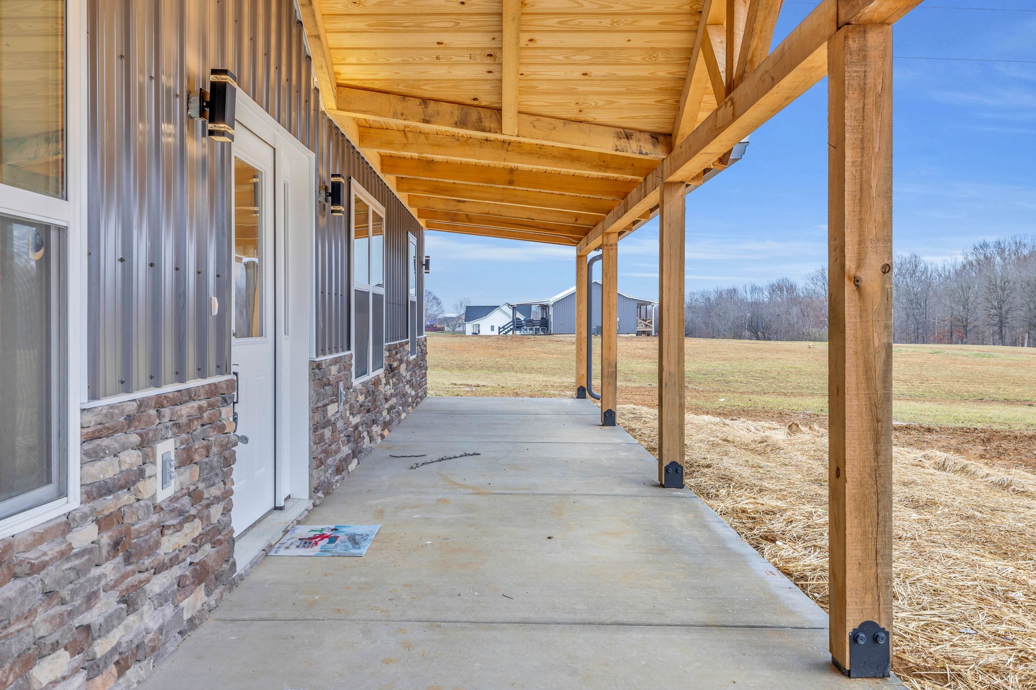 129 Colonial Road Hohenwald, TN 38462 - Photo 4 of 33 a view of a porch with a table and chairs and wooden floor