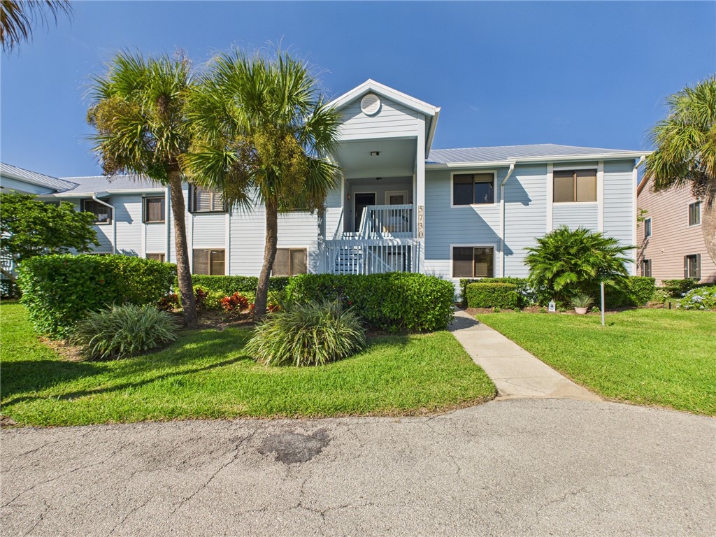 5730 Pelican Pointe Drive, Unit 2 Sebastian, FL 32958 - Photo 1 of 19 a front view of a house with a garden and trees