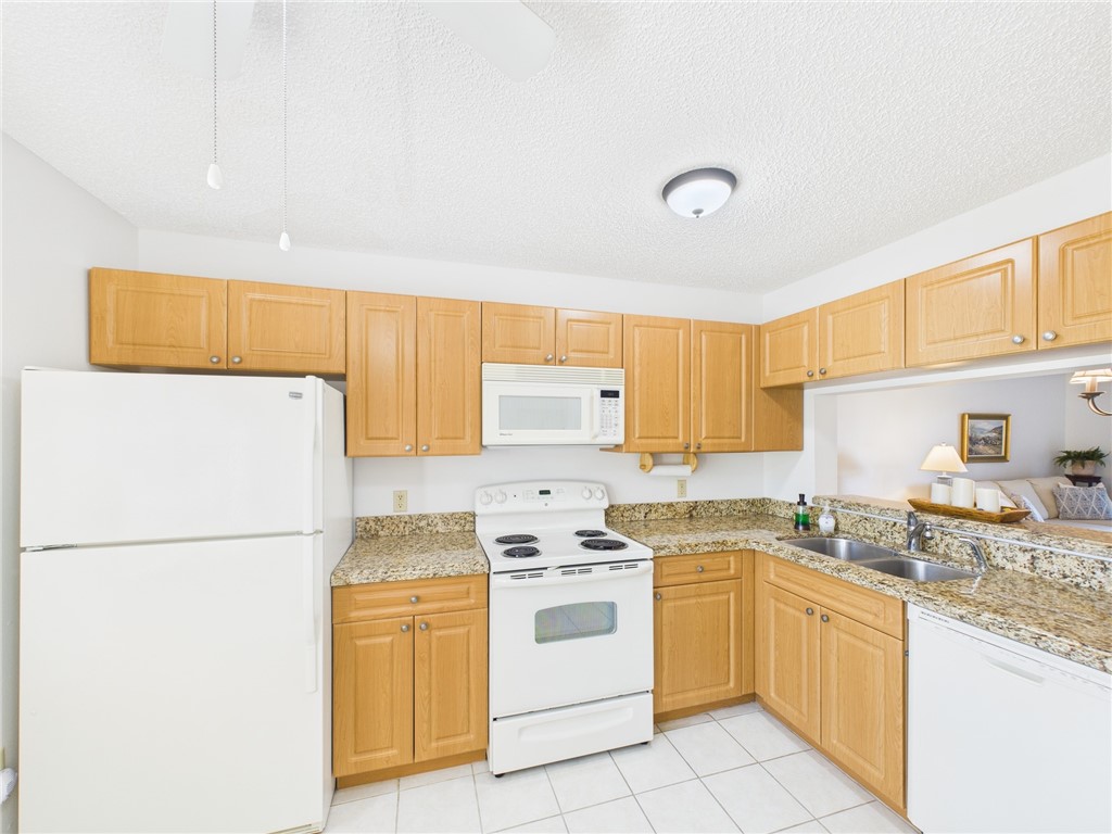 5730 Pelican Pointe Drive, Unit 2 Sebastian, FL 32958 - Photo 13 of 19 a kitchen with a white cabinets and white appliances