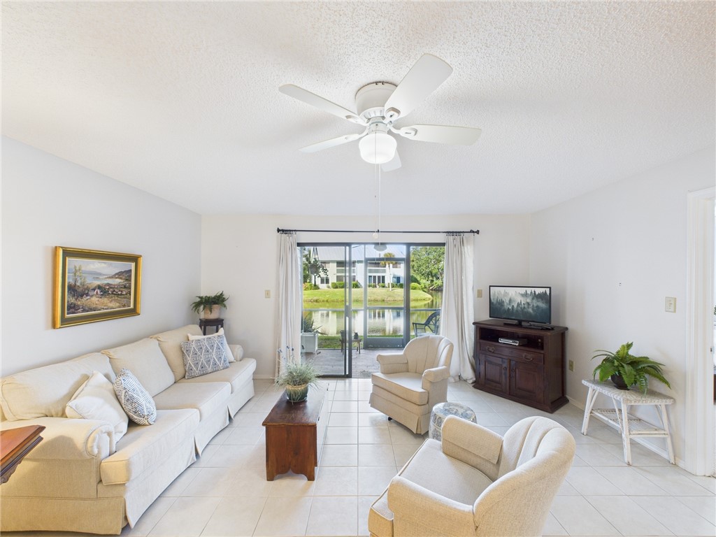 5730 Pelican Pointe Drive, Unit 2 Sebastian, FL 32958 - Photo 19 of 19 a living room with furniture ceiling fan and a large window