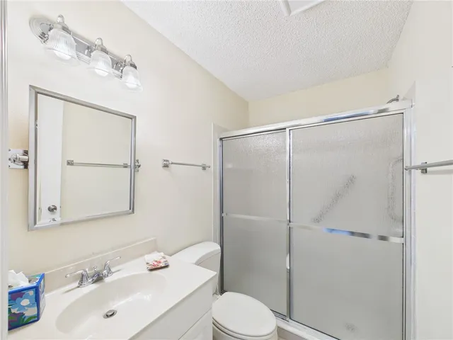 a bathroom with a sink vanity mirror and toilet