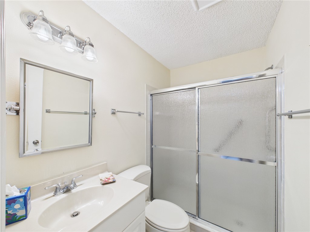 5730 Pelican Pointe Drive, Unit 2 Sebastian, FL 32958 - Photo 5 of 19 a bathroom with a sink vanity mirror and toilet