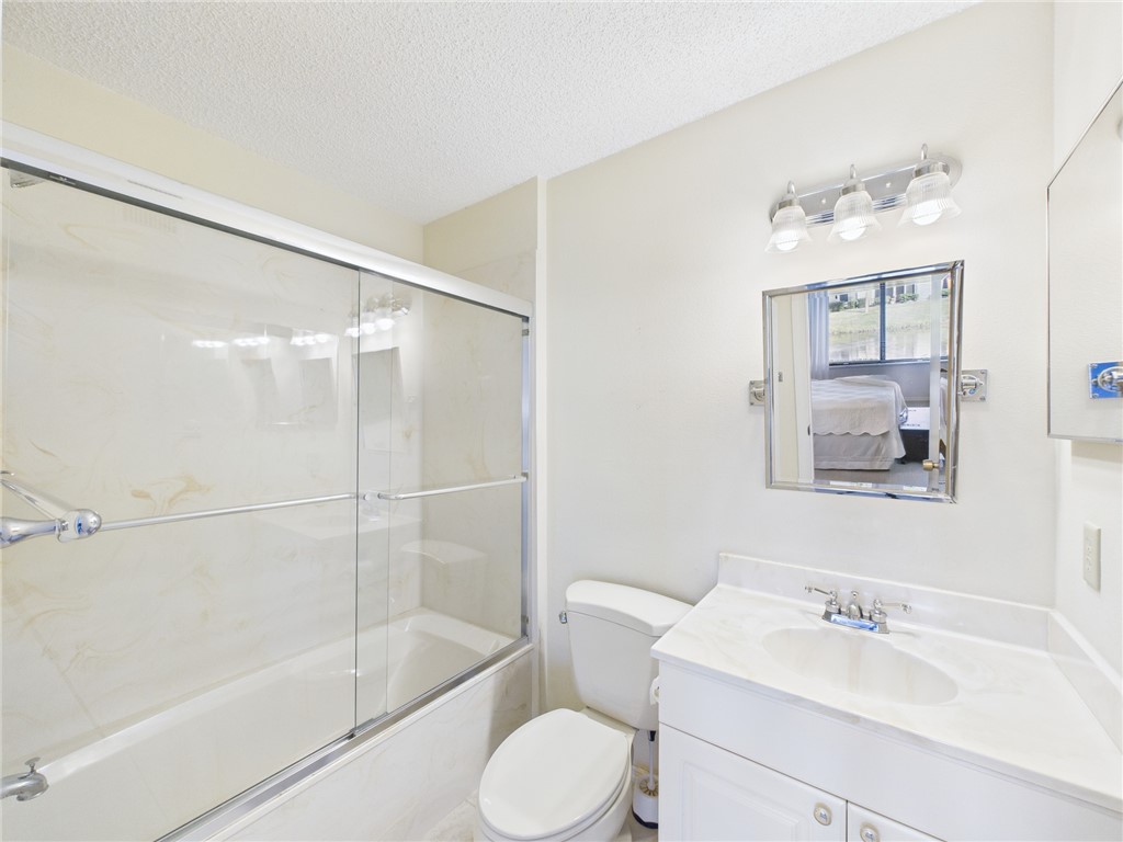 5730 Pelican Pointe Drive, Unit 2 Sebastian, FL 32958 - Photo 8 of 19 a bathroom with a sink toilet and shower